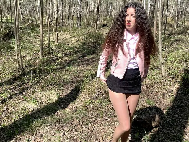 Schönes Mädchen in einem Minirock pinkelte in den Wald