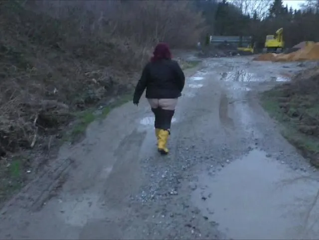 Nackter Po und Gummistiefel
