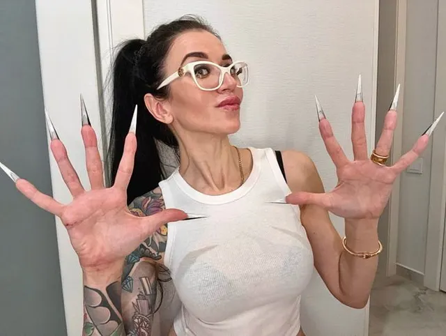 Fingerschnippen und Fingerlutschen mit langen Nägeln, weißer Brille und Gesicht