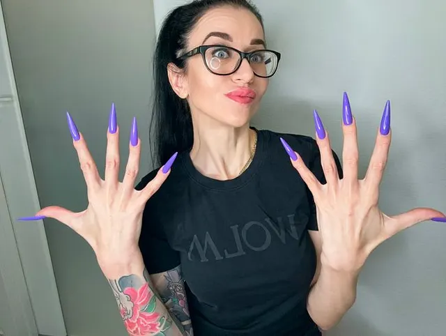 Fingerschnippen und Fingerlutschen mit langen lila Nägeln, Brille und Gesicht
